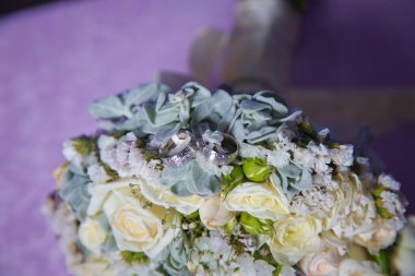 Bir buket beyaz gül. Bir buket çiçekte düğün için altın yüzükler. Beyaz düğün gül buketi.