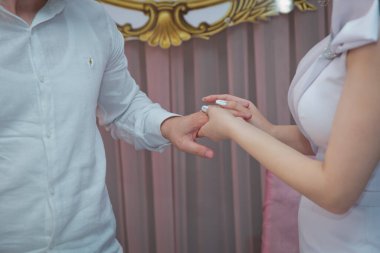 Bir adam kız arkadaşına yüzük veriyor ve parmağına takıyor. Erkek arkadaşı kahvaltıda kına yüzüğü verdiği için yakalanan genç bir kadın. Düğün gününde bir yüzük takıyor..