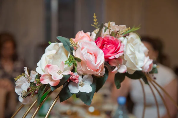 colorful flowers in a basket . Engagement flowers basket . The handle of the engagement basket . There are candies in the basket decoration . Artificial flowers .