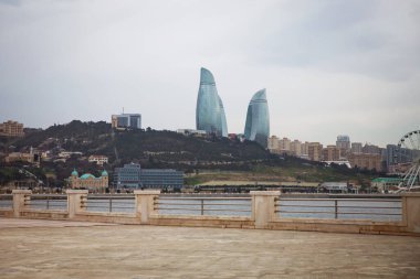 BAKU, AZERBAIJAN - 31.03.2021: Hazar Denizi 'nden Alev Kulelerine Görünüm. Bakü Alev Kuleleri, Azerbaycan 'ın Bakü kentindeki en yüksek gökdelendir.