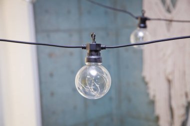 Edison Lambası çatı katının içinde. Dekorasyon için gün ışığında barda asılı ampuller. Bir ampul. Sokak çelengi elementi.