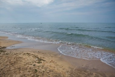 Tropikal deniz dalgalarının turkuaz suyu suyun üzerinde. Akdeniz kıyısı. Dalgalar kıyıya vuruyor. Cennet vahşi plajı. Derin mavi okyanus. Kumsal ve su yüzeyinde dalgalar.