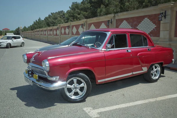 旧ロシア車GAZ-21 Volgaのクローズアップビューが庭に駐車しました。1950年代から1960年代のソ連のレトロな車。ヴィンテージ輸送だ。赤の有名なレトロな輸送。アゼルバイジャン、バクー。06.06.2021: — ストック写真