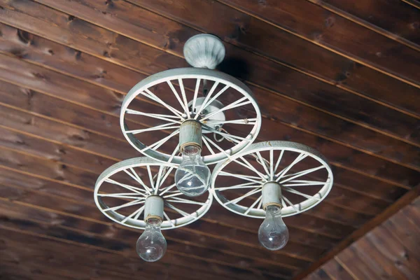 Moderna lámpara colgante arte y ciencia. Antigua decoración de iluminación vintage. Luces hechas de hierro blanco carruaje tirado por caballos. grupo de luces colgantes en cafetería con poca profundidad de campo, diseño de interiores . — Foto de Stock