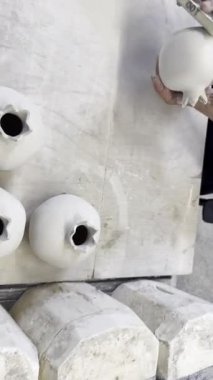 Seramik kil ürünleri raf yakın çekim üzerinde durmak. Heykeltraş beyaz kil tencere urun sculpts. Karanlık. Atölye seramik. Ana sakat. Kültürel gelenekleri. El yapımı. Zanaat. Bükülmüş potters tekerlek.
