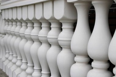 Beyaz balyalar sıraya dizilir ve bir yapı boyunca bir bariyer oluşturulur. Çekim her sütunun şeklini ve düzenini iyi bir aydınlatma ile yakalar..