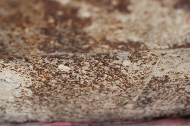 Yüzey, zamanın ve havanın etkilerini gösteren pas ve aşınmanın detaylı bir örneğini gösteriyor. Ayarlar muhtemelen elementlere maruz kalan bir açık alan..