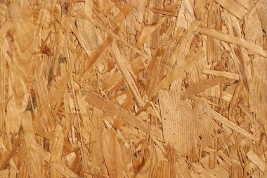 Ahşap maddeden yapılmış bir yüzey birbiri üzerine katmanlanmış ince ve kalın parçalar sergiler. Bu materyal inşaat projeleri ve çeşitli ahşap işleri için kullanılabilir.