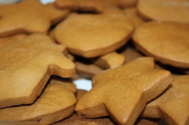 Pişirme oturumu yıldızlı ve yuvarlak şekilli kurabiyeler bir masada otururken gerçekleşir. Kurabiyeler Noel kutlamasından önce dekorasyon için hazır..