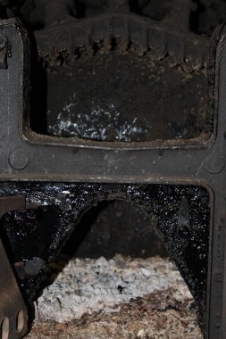 Dökme demir soba ahşap ile pişirdikten sonra kurum ve kül manzarasını gösterir. Soba karanlık ve ahşap kalıntılarıyla dolu. Ayarlar mutfak alanında..