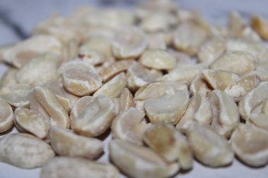 Soyulmuş fıstıklar bir yüzeye yayılır. Bu fındıklar yemek için hazır ya da çeşitli tariflerde kullanılabilir. Ortam doğal ışıkla aydınlık..