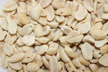 Küçük, kabuklu fıstıklar düz bir yüzeyde bir araya getirilir. Işıklandırma fındıkların dokusunu ve rengini gösteriyor. Arkaplan tarafsız ve konudan sapmıyor..