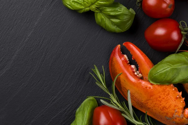 Perna de lagosta no fundo preto com ervas e tomates — Fotografia de Stock