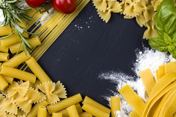 Torkad pasta på svart sten bakgrund, pasta koncept — Stockfoto