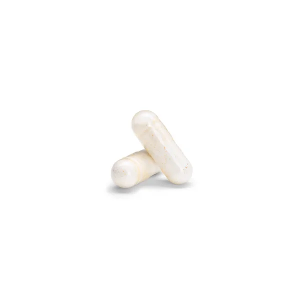 Close-up of a couple pills or capsules color yellow on isolated white background. — Stock Photo, Image