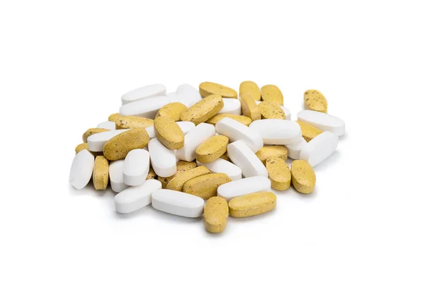 Close-up of a pile of yellow and white colored pills or capsules on isolated white background. Selective Focus. — Stock Photo, Image