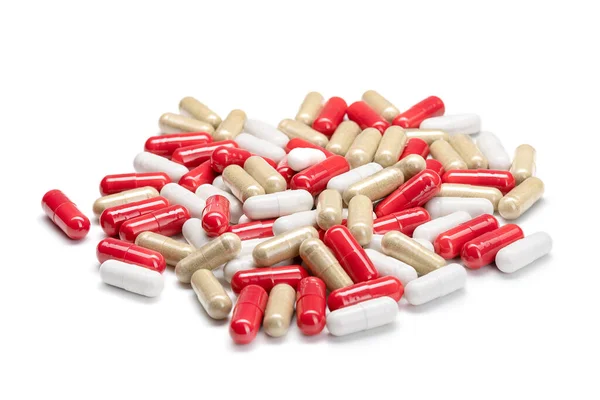 Närbild av en hög med piller eller kapslar i olika färger på isolerad vit bakgrund. Selektiv inriktning. — Stockfoto