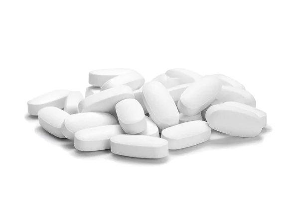 İzole edilmiş beyaz arka plandaki beyaz renkli hapların ya da kapsüllerin yakın çekimi. Seçici Odaklanma.