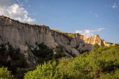 Manzaralı yeşil yuvarlanan tepeler mavi gökyüzüne karşı bulutlarla.