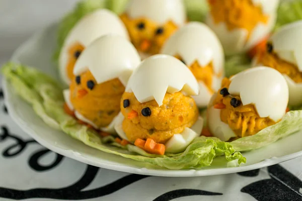 Haşlanmış süs yumurtalarının aperatifi marulun üzerine yerleştirilmiş küçük civciv şeklinde. Paskalya süsü. Seçici Odaklanma.