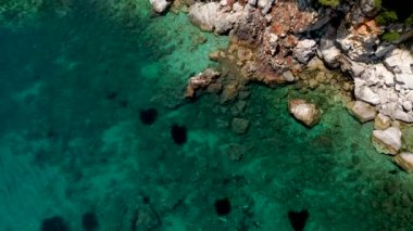 Uçağı kayalık bir kıyı şeridi, kristal berraklığında Ege suları, turistik plajlar ve Yunanistan 'ın Benzer pek çok Yunan adasının tipik bir görüntüsü.