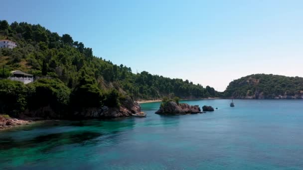 Letecké drone názory na skalnaté pobřeží, křišťálově čisté Egejské moře vody, turistické pláže a spousta zeleně na ostrově Skopelos, Řecko. Typický pohled na mnoho podobných řeckých ostrovů. — Stock video