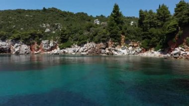 Uçağı kayalık bir kıyı şeridi, kristal berraklığında Ege suları, turistik plajlar ve Yunanistan 'ın Benzer pek çok Yunan adasının tipik bir görüntüsü.