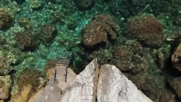 Повітряний дрон дивиться на скелясте узбережжя, кришталево чисті води Егейського моря, туристичні пляжі і багато зелених на острові Скопелос, Греція. Типовий вид на багато подібних грецьких островів. — стокове відео