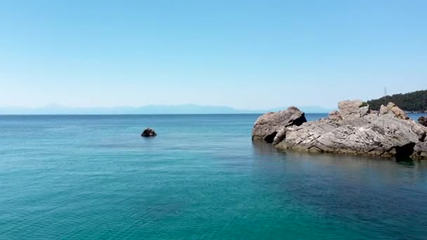 Vistas aéreas de drones sobre um litoral rochoso, águas cristalinas do mar Egeu, praias turísticas e muita vegetação na ilha de Skopelos, Grécia. Uma vista típica de muitas ilhas gregas semelhantes. — Vídeo de Stock