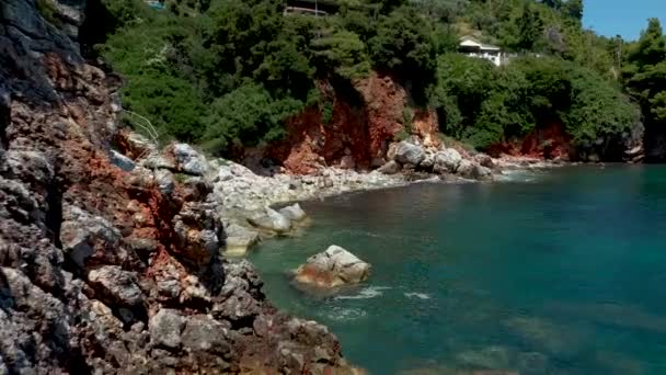 Letecké drone názory na skalnaté pobřeží, křišťálově čisté Egejské moře vody, turistické pláže a spousta zeleně na ostrově Skopelos, Řecko. Typický pohled na mnoho podobných řeckých ostrovů. — Stock video