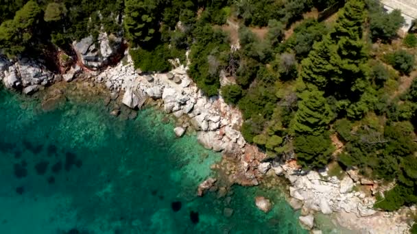 Drohnenbilder aus der Luft über einer felsigen Küste, kristallklarem Ägäischen Meer, touristischen Stränden und viel Grün auf der griechischen Insel Skopelos. Ein typischer Blick auf viele ähnliche griechische Inseln.