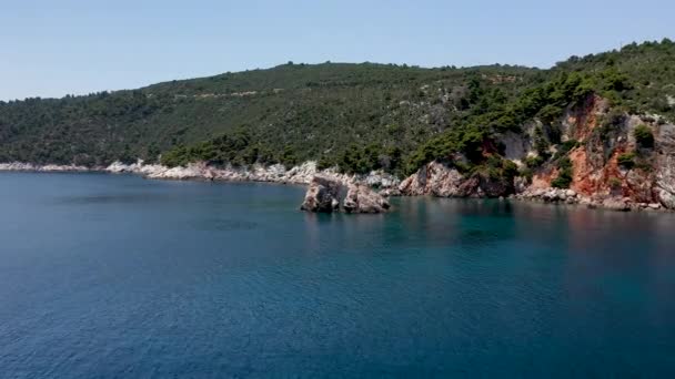 Drohnenbilder aus der Luft über einer felsigen Küste, kristallklarem Ägäischen Meer, touristischen Stränden und viel Grün auf der griechischen Insel Skopelos. Ein typischer Blick auf viele ähnliche griechische Inseln. — Stockvideo