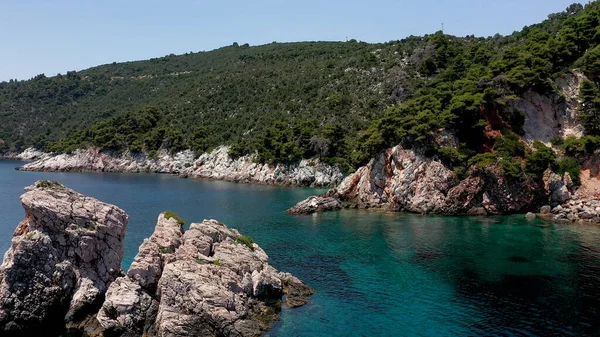 Letecké drone názory na skalnaté pobřeží, křišťálově čisté Egejské moře vody, turistické pláže a spousta zeleně na ostrově Skopelos, Řecko. Typický pohled na mnoho podobných řeckých ostrovů. — Stock fotografie