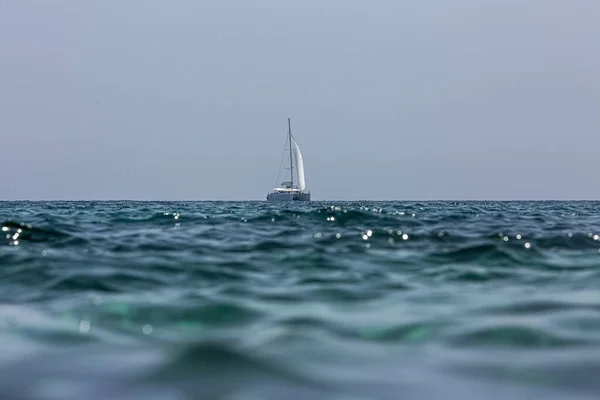 White sailing boat catamaran on ocean near beach. Royalty Free Stock Photos