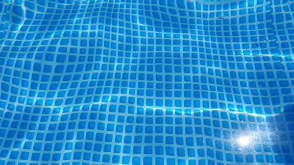 Textura de la superficie del agua con rizos limpios en la piscina ondulaciones y olas. — Foto de Stock