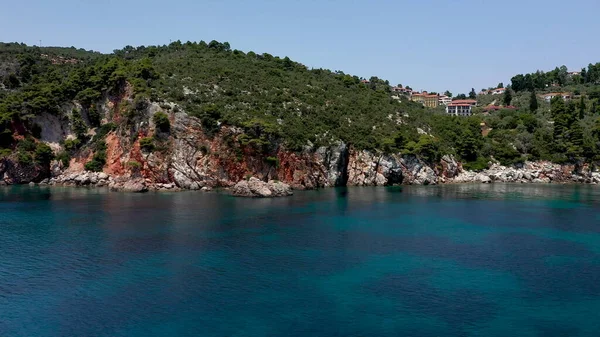 Vedute aeree drone su una costa rocciosa, acque cristalline del Mar Egeo, spiagge turistiche e un sacco di verde nell'isola di Skopelos, Grecia. Una vista tipica di molte isole greche simili. — Foto Stock