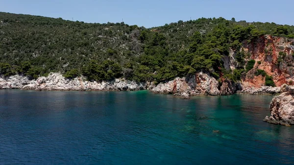 岩の多い海岸線、透明なエーゲ海、観光ビーチ、ギリシャのスコフェロス島の緑の多くの上空のドローンの眺め。多くの似たようなギリシャの島々の典型的な眺め. — ストック写真