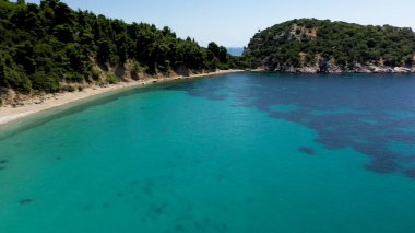 Uçağı kayalık bir kıyı şeridi, kristal berraklığında Ege suları, turistik plajlar ve Yunanistan 'ın Benzer pek çok Yunan adasının tipik bir görüntüsü.