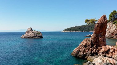 Uçağı kayalık bir kıyı şeridi, kristal berraklığında Ege suları, turistik plajlar ve Yunanistan 'ın Benzer pek çok Yunan adasının tipik bir görüntüsü.