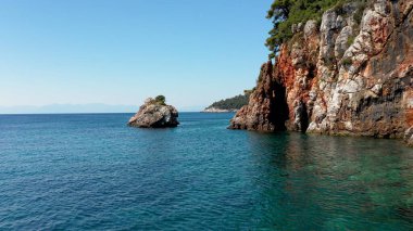 Uçağı kayalık bir kıyı şeridi, kristal berraklığında Ege suları, turistik plajlar ve Yunanistan 'ın Benzer pek çok Yunan adasının tipik bir görüntüsü.