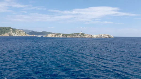 Yunanistan 'da deniz feneri olan bir Ege Adası manzarası. Sudan fışkıran.