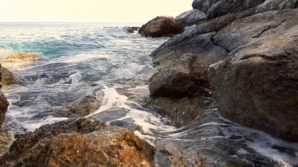 Gün batımında kayalara vuran küçük dalgalar.. — Stok fotoğraf