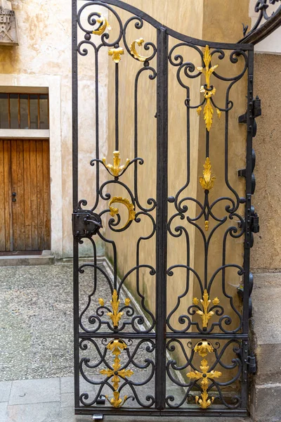 Süslü, yarı açık demir bir kapı..