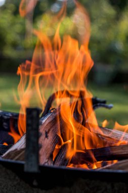 Güneşli bir günde, bir barbekü partisinde yanan ateş..