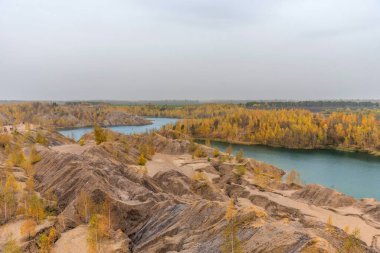 Rusya 'nın Tula bölgesinde, Konduki' de sarı ağaçlar, pitoresk tepeler ve mavi göller ile hava sonbahar manzarası. Romantsevo 'daki turkuaz ocağı. Ushakovskiye taş ocakları.