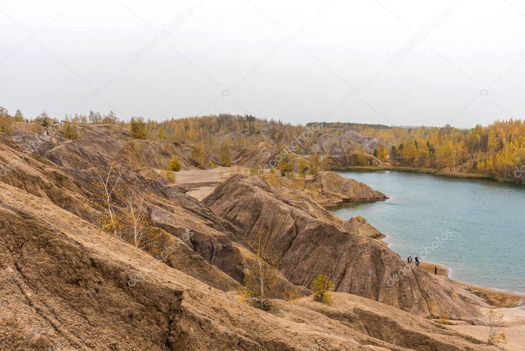 Aerial Autumn view with yellow trees, picturesque hills and blue lakes in Konduki, Tula region, Russia. Turquoise quarry in Romantsevo. Ushakovskiye quarries.
