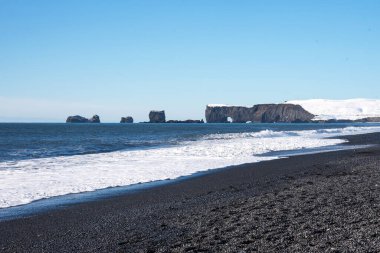 Dyrholaey, İzlanda 'nın kış manzarası. Siyah kumlu, deniz fenerli ve okyanusta volkanik kayalardan oluşan büyük kemerli güzel bir yarımadanın kış manzarası..