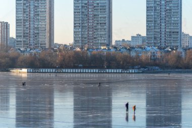Moskova, Rusya - 4 Aralık 2020: İnsanlar Rusya 'daki donmuş Moskova Kanalı' nda kayıyorlar. Donmuş nehirdeki insanlar. Moskova Kanalı 'nın insanlarla dolu kış manzarası. Moskova 'daki donmuş kanal..