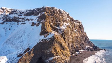 Reynisdrangar, İzlanda 'da Atlantik Okyanusu kıyıları ve siyah kumlu plajın manzarası. Reynisdrangar, İzlanda 'nın güzel kış manzarası.