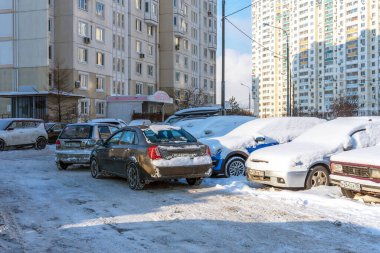 Moskova, Rusya - 18 Şubat 2021: Moskova 'da yoğun kar yağışı sonrasında karla kaplı arabalar. Şiddetli bir kar yağışı sonrası yerleşim bölgesinde bir yol. Araba karla kaplı ve bir yerleşim yerinin avlusuna park edilmiş..